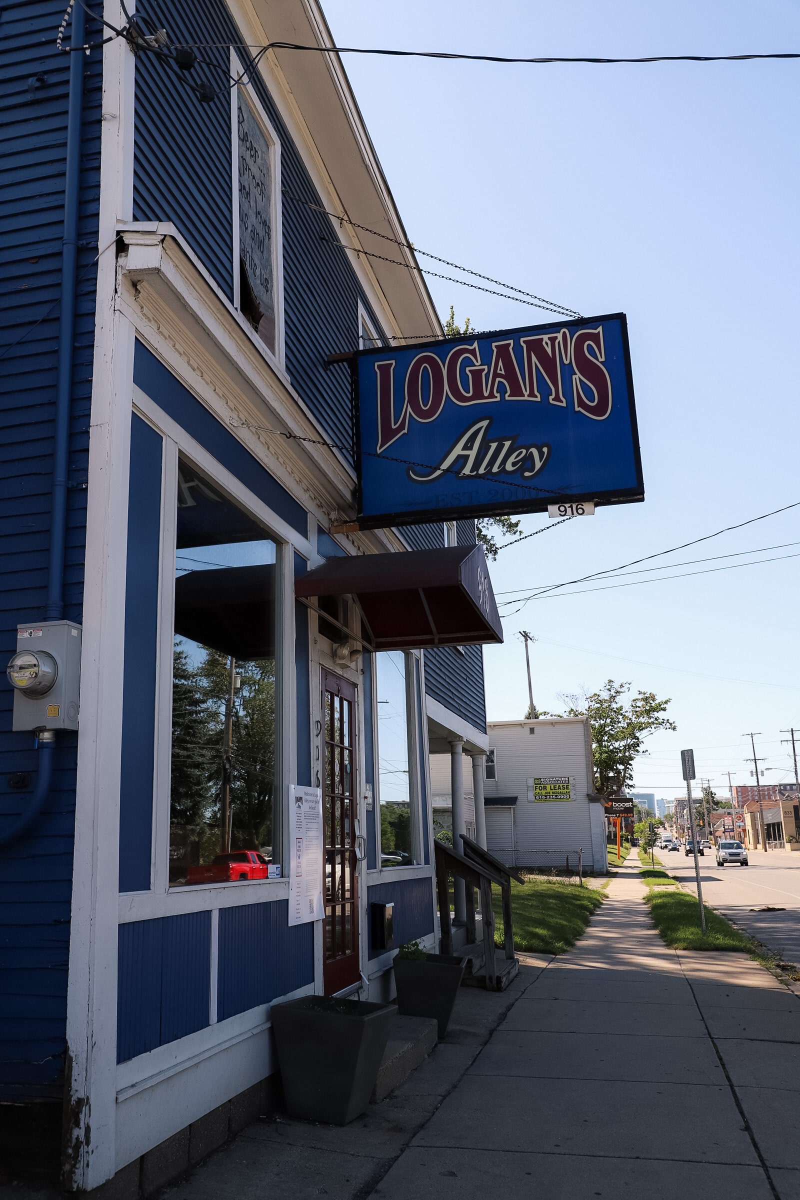 Logan's Alley blue wood-sided exterior and hand-painted sign on Michigan Street